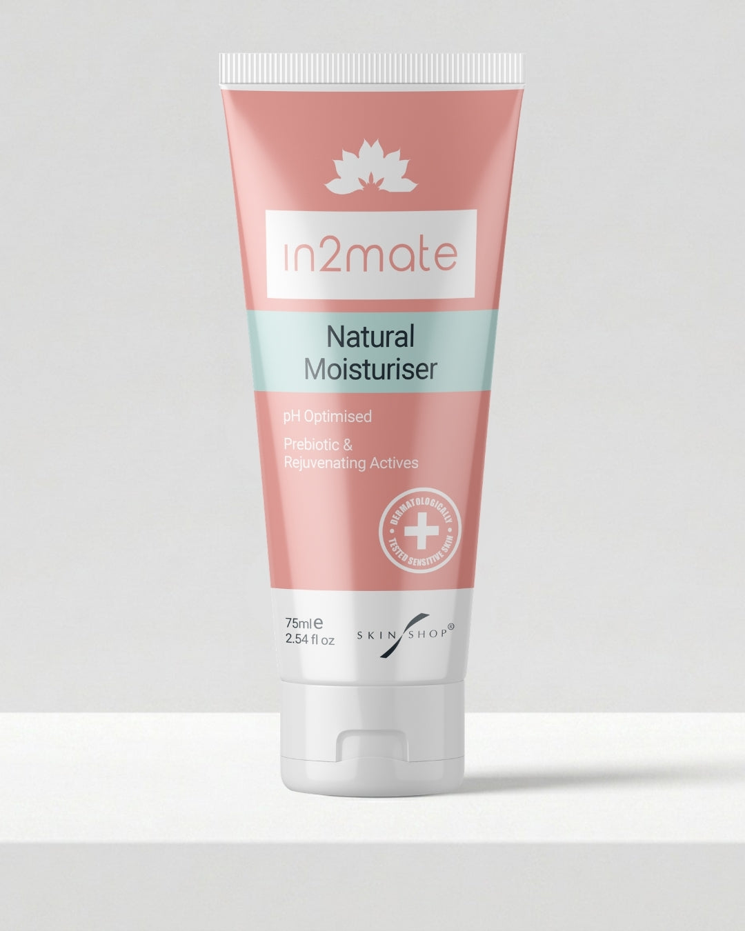 A squeeze tube of in2mate Natural Moisturiser on a light grey surface against a neutral grey background.