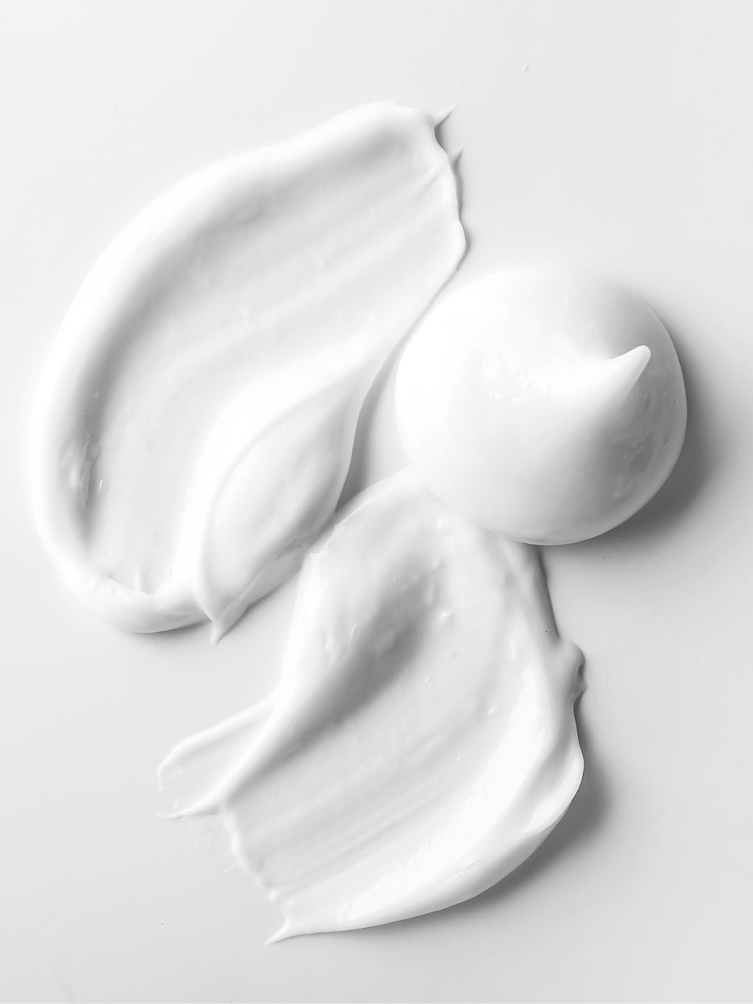 Swirls and a dollop of smooth white cream, representing dicaprylyl carbonate, the light plant-derived emollient that gives KALME Undercoat its non-greasy finish