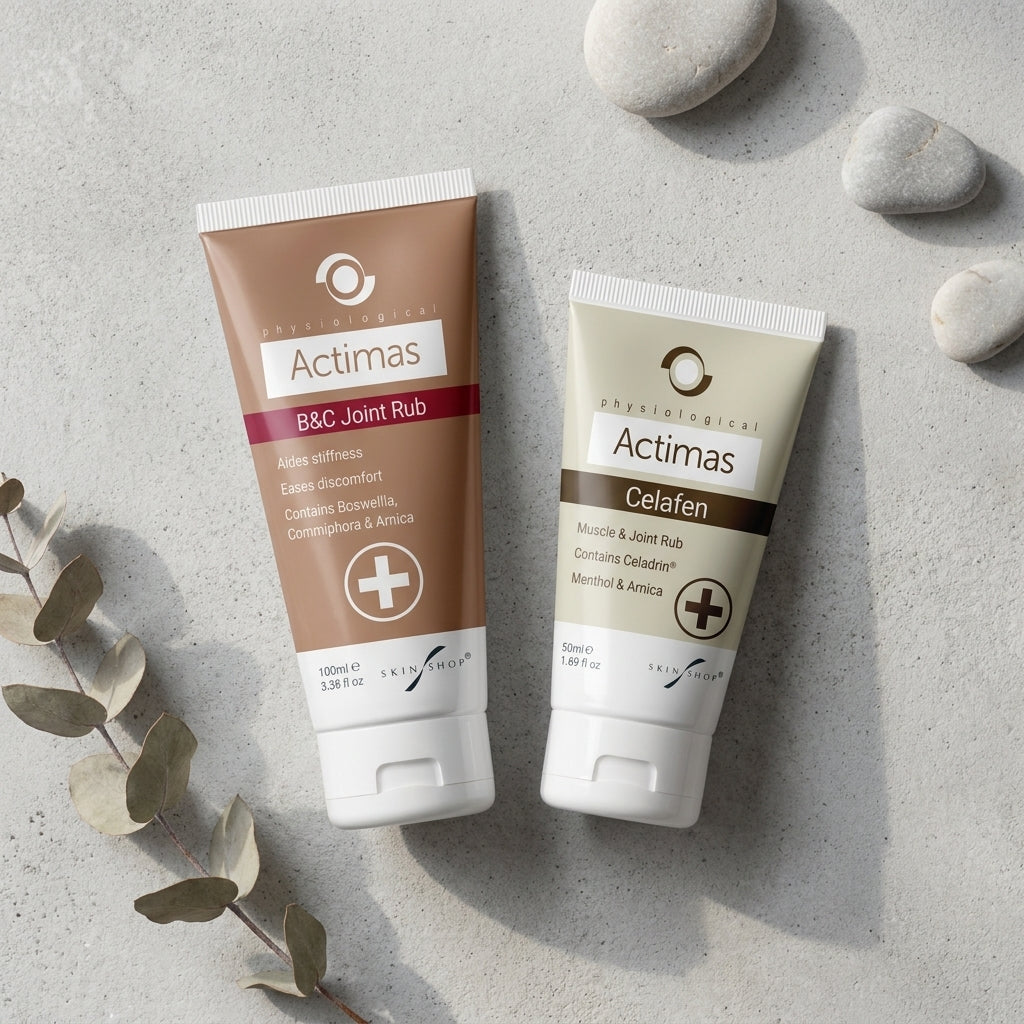 Two Actimas cream tubes on a gray surface with stones and eucalyptus leaves.