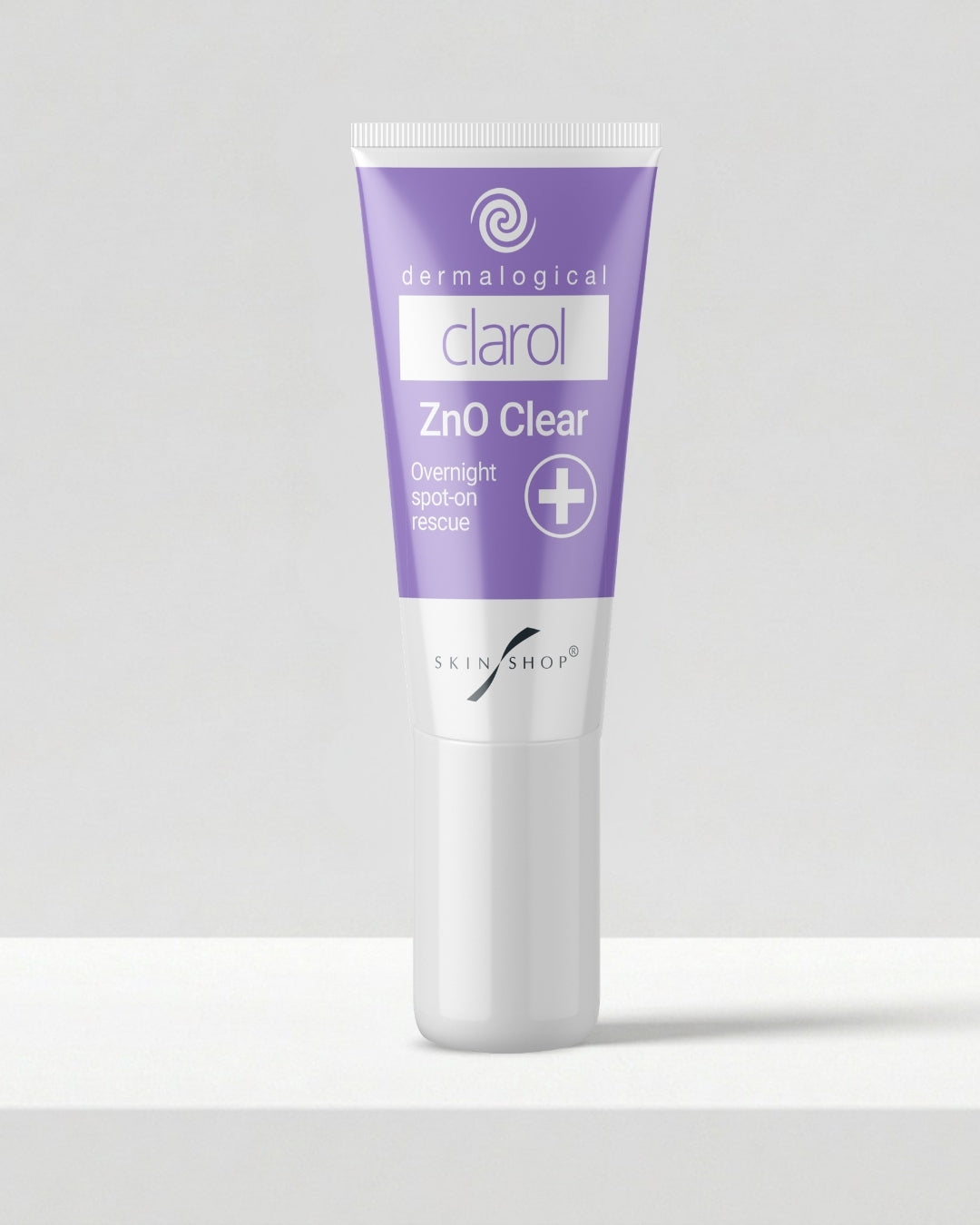 A squeeze tube of Clarol ZnO Clear overnight spot-on rescue skincare cream for acne-prone skin by Skin Shop, featuring a lavender purple and white design, standing on a white surface against a light gray background.