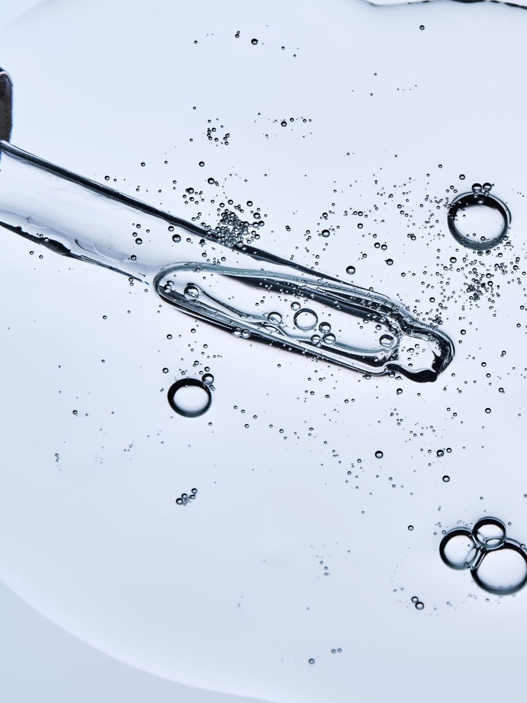 A clear, hydrating gel texture with a glass dropper and air bubbles, illustrating glycerin, the humectant in Hydrosil Dry Eye Gel