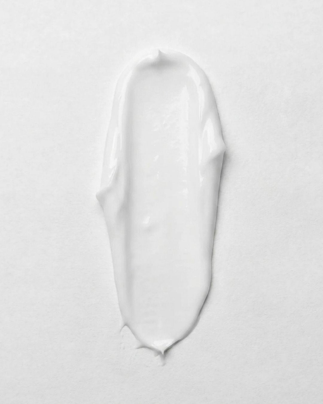 Texture swatch of KALME Undercoat, a light white cream with a smooth, non-greasy consistency.